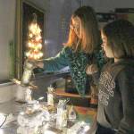 Coupeville Elementary School art teacher Kim McWilliams and second-grader Kaleah Matros pick out Matros foil recycled item sculpture. The students focused on the idea of light for their pieces shown Tuesday night. Photo by Laura Guido/Whidbey News-Times