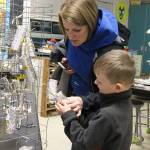 Kindergartner Hunter Coatney, shows his mom Adriaenne Coatney his foil cylinder at Tuesdays art show at Coupeville Elementary School. Photo by Laura Guido/Whidbey News-Times