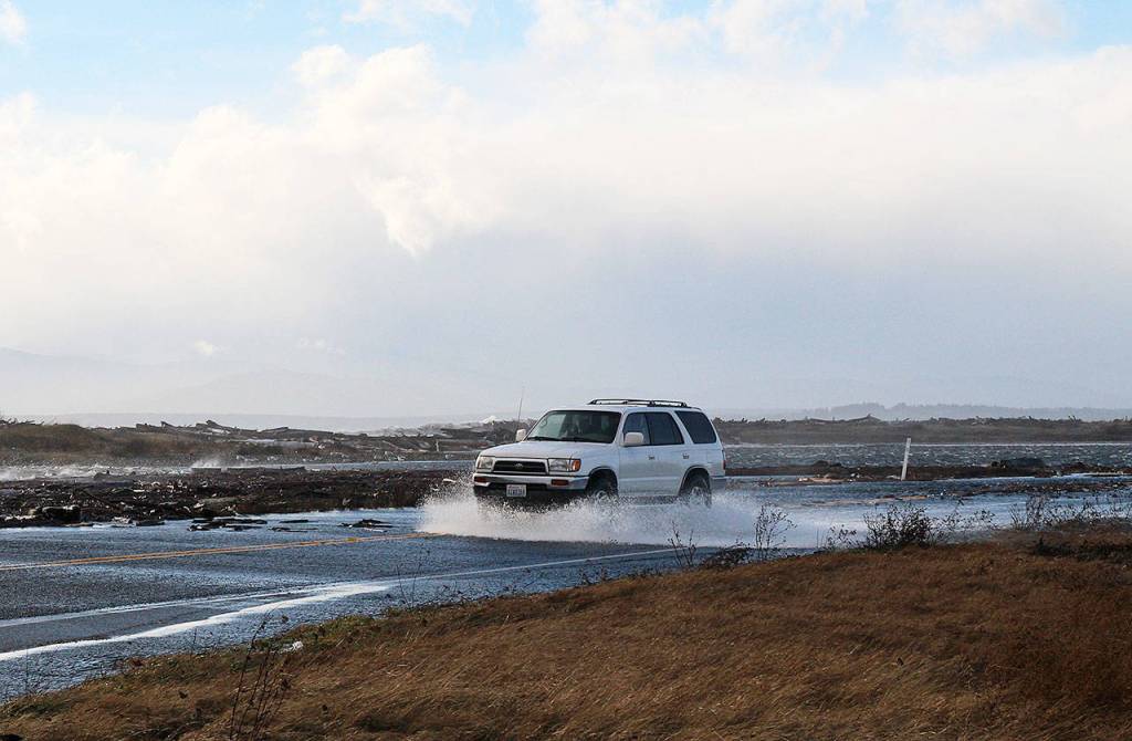 Photo by Laura Guido/Whidbey News-Times.                                A vehicle drives through the flooded Keystone Avenue Thursday.
