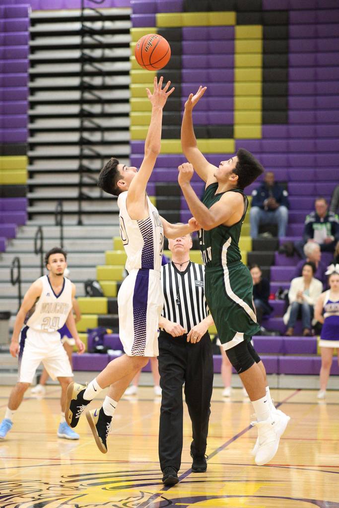Matt Kelley, left, takes the opening tip for Oak Harbor. (Photo by John Fisken)