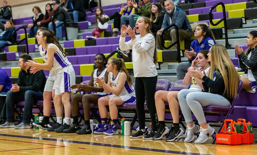 The Oak Harbor reacts to a positive play by the Wildcats. Starters Mirada Wilson (standing center) and Payton Parks (far right) missed the game becasue of injuries. (Photo by John Fisken)