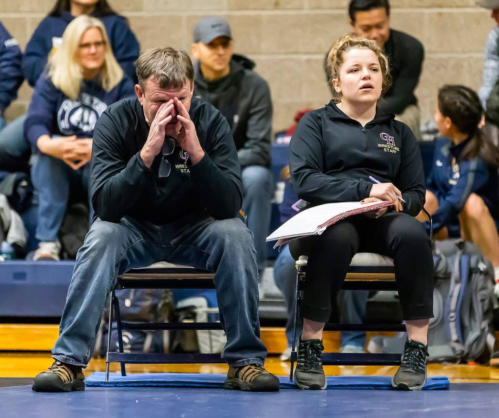 Oak Harbor coaches Brian Farmer, left, and Erin Locke take in the action of their wrestlers Saturday. (Photo by John Fisken)