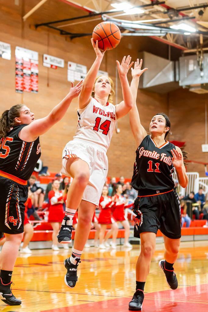 Ema Smith splits the defense of Granite Falls Sadie Hutchinson, left, and Jennifer Rodenbaugh.(Photo by John Fisken)