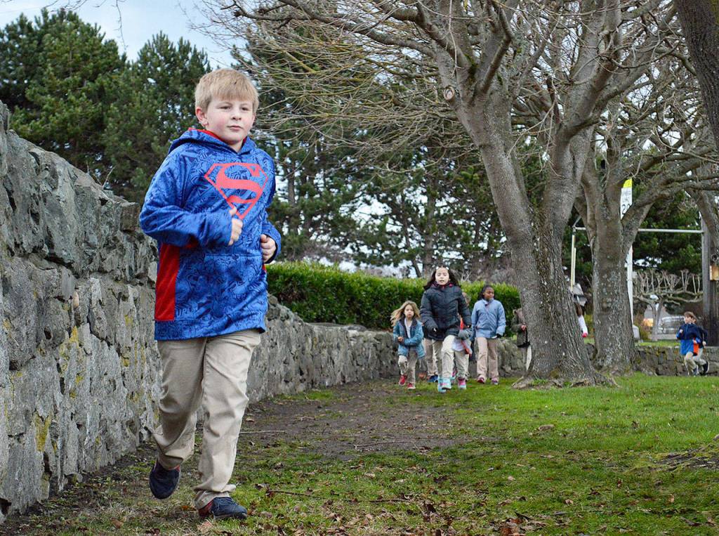 Tyler Hettenbach completes a lap Thursday morning at Oak Harbor Elementary School. The Marathon Kids running club meets three times a week and each participate tries to accumulate a marathon-worth of miles, 26.2. Photo by Laura Guido/Whidbey News-Times