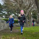 Kylie Hawkins, left, and Katrin Kurganov finish a lap strong. Students receive a Popsicle stick after a lap to keep track of how far they go. Photo by Laura Guido/Whidbey News-Times