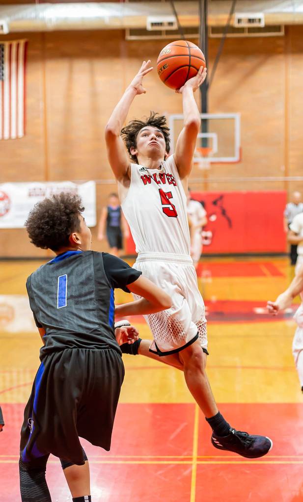Hawthorne Wolfe (5) flies by South Whidbeys Jacob Ng.(Photo by John Fisken)