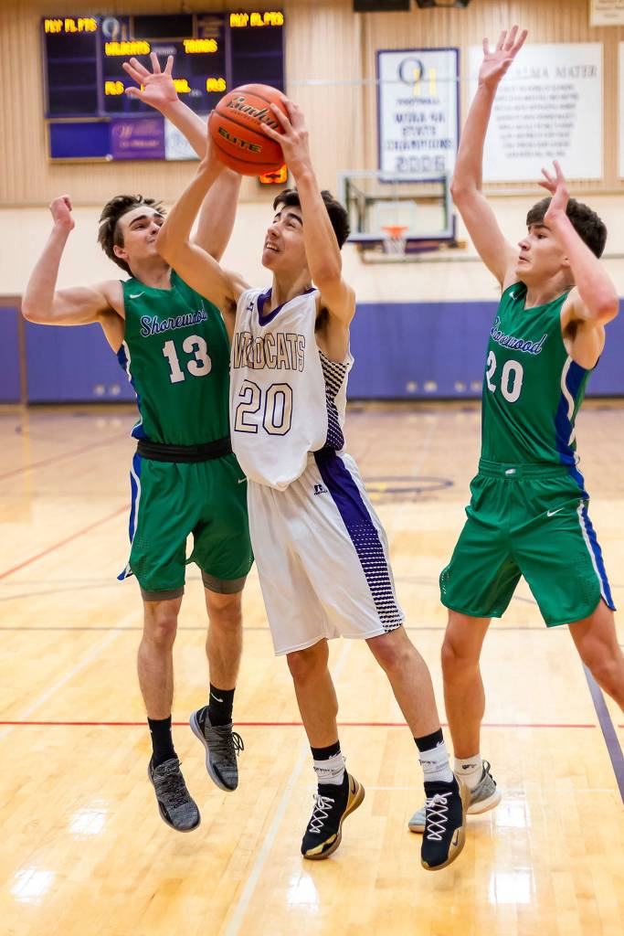 Matt Kelley splits the defense of Shorewoods Samuel Burns (13) and Jackson Galiardi (20) for 2 points.(Photo by John Fisken)