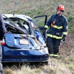 Central Whidbey Island Fire and Rescue Lt. James Meek inspects damage to a prius after a rollover accident off Highway 20 Monday afternoon. Photo by Laura Guido/Whidbey News-Times