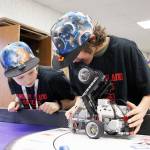 Addie Nigro, left, and Tobias Wood inspect Home Connection Phoenixs robot as the FIRST Lego robotics team prepares for the state competition in Kent. Photo by Laura Guido/Whidbey News-Times