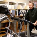 New stores director Tony Persson demonstrates that home exercise equipment is sometimes donated and put up for sale at the Oak Harbor Habitat for Humanity store. (Photo by Patricia Guthrie/Whidbey News-Times)