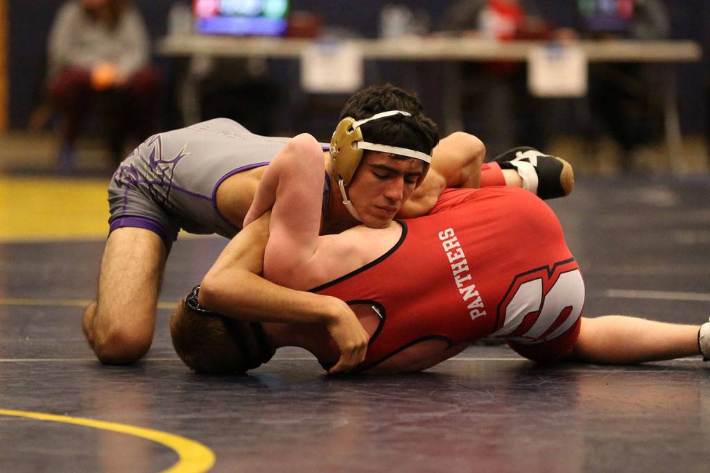 Oak Harbors Caleb Fitzgerald, top, defeats Snohomishs Tyson Johnson in the first round of the subregional tournament. Fitzgerald won four straight matches to claim the 126-pound title.(Photo by John Fisken)