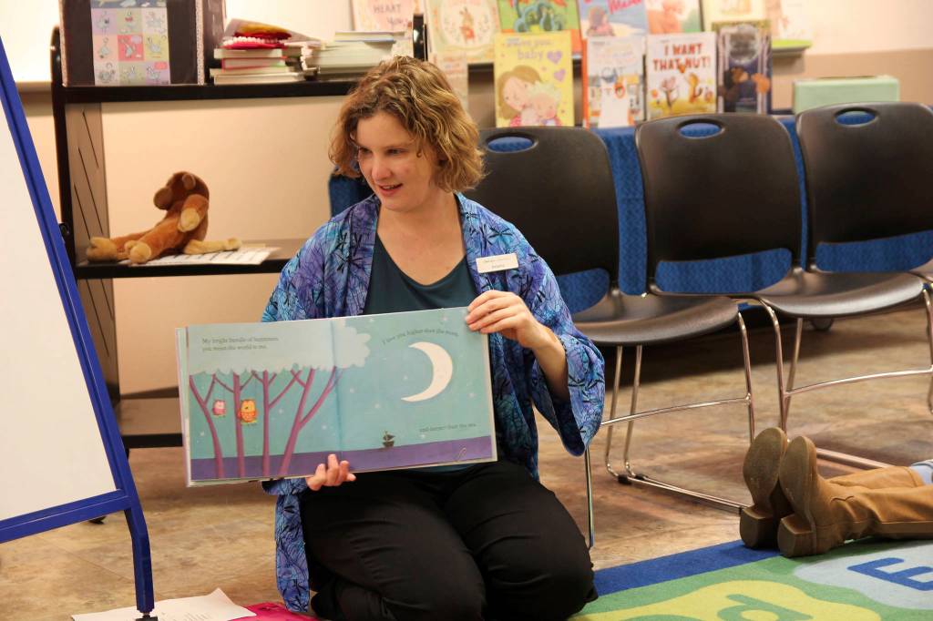 (Photo by Maria Matson/Whidbey News-Times)                                Natasha Vanderlinden ran Thursdays Baby Storytime because regular leader, Library Associate Rhianna McBride, couldnt make it in due to weather. Vanderlinden usually runs the librarys Toddler Storytime. Here, she reads a book to the babies. Vanderlinden said she was enjoying leading the group.