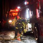 Lt. Marv Raavel, with Central Whidbey Island Fire and Rescue, gathers a hose used to extinguish a residential fire Thursday night in Coupeville. No one was injured, but the home sustained significant smoke damage. Photo by Laura Guido/Whidbey News-Times