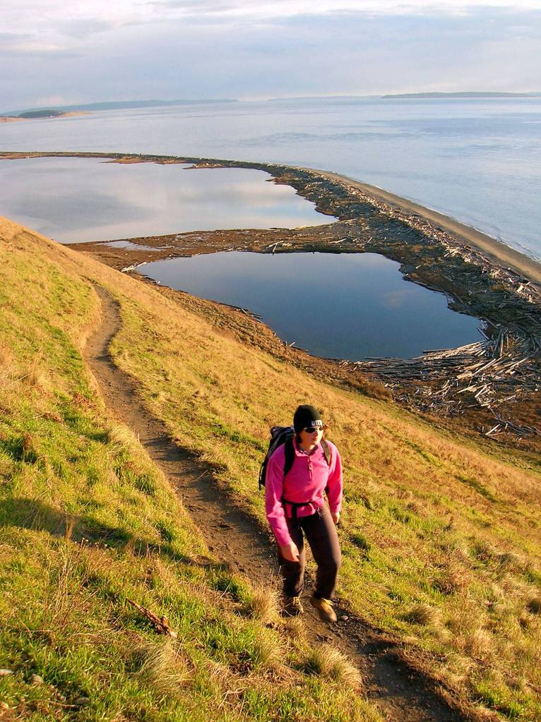 Photo by Craig Romano                                 Heather Romano hikes the Bluff Trail at Ebeys Landing Historical Reserve on Whidbey Island.