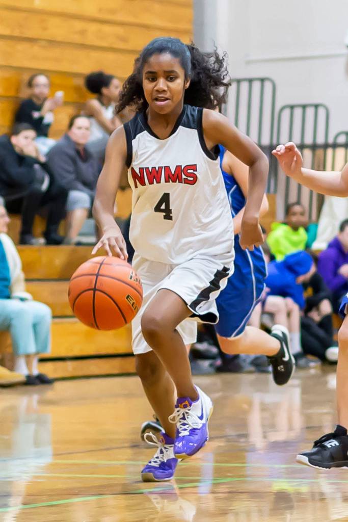 Eighth-grader Nerya Rennes hustles the ball up the court.(Photo by John Fisken)