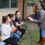 From left, third- and fourth-graders Avery Bower, Kimora Drexler, Aubrey Bower and Laila Hernandez listen to Green Team mentor Kamie Beach as she explains how to hang hummingbird feeders in the new enchanted ecosystem at Crescent Harbor Elementary School. (Photos by Laura Guido/Whidbey News-Times)