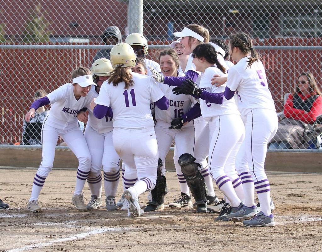Kayla Crocker (11) is met at home plate by her teammates after hitting a home run against Coupeville.(Photo by John Fisken)