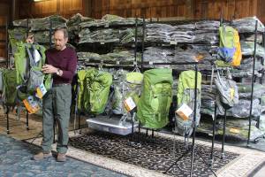 Rich Murphy uses an old barn as a warehouse for a line of backpacks called Aarn that are designed in New Zealand and sold worldwide. Murphy and his wife, Genie, are the new North American distributers for the backpacks that emphasis balance and reducing strain while hiking. (Photo by Patricia Guthrie/Whidbey News Group)                                Rich Murphy shows tandem packs that can attach to backpacks and be worn in front to help with balance. (Photos by Patricia Guthrie/Whidbey News Group)                                The backpacking equipment company called Aarn began when New Zealander founders Aarn Tate and Devi Benson began designing outdoor products to be more body-comfortable. The material is extremely tough but light and durable. The stores balance bags run around $70 to $150 and the full backpacks $200 to $400.
