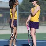 Frances Eminado, left, and Monique Stolmeier talk strategy during a break in first doubles.(Photo by John Fisken)