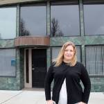 Sarah Schacht stands in front of one of the buildings she owns in downtown Oak Harbor. (Photo by Jessie Stensland / Whidbey News-Times)