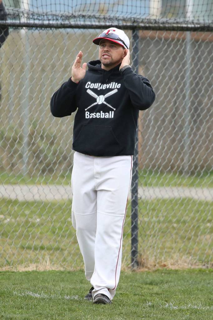 Coach Chris Smith relays signals to a Coupeville batter.(Photo by John Fisken)