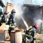 Lt. James Meek, Central Whidbey Island Fire and Rescue, directs a fire hose into a storage container filled with hay. The hay inside caught fire Tuesday when the metal shipping container became too hot from a slow burn outside. Photo by Laura Guido/Whidbey News-Times