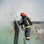 Lt. James Meek, Central Whidbey Island Fire and Rescue, inspects a storage container full of hay that caught fire Tuesday outside of Coupeville. Photo by Laura Guido/Whidbey News-Times