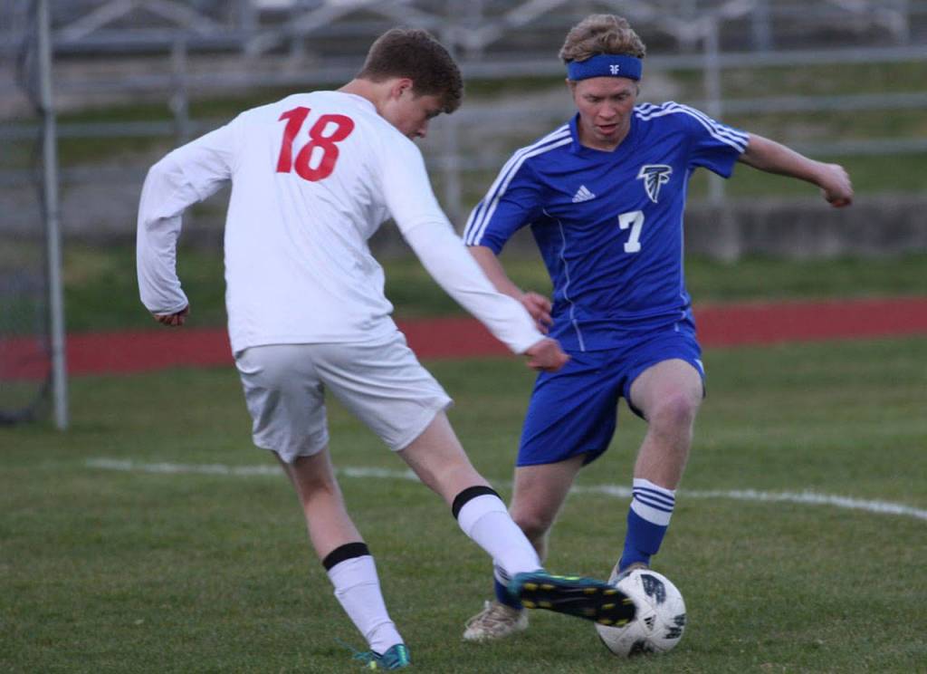 Sage Downes (18) tries to punch the ball by South Whidbeys Eli Waldron.(Photo by Matt Simms)