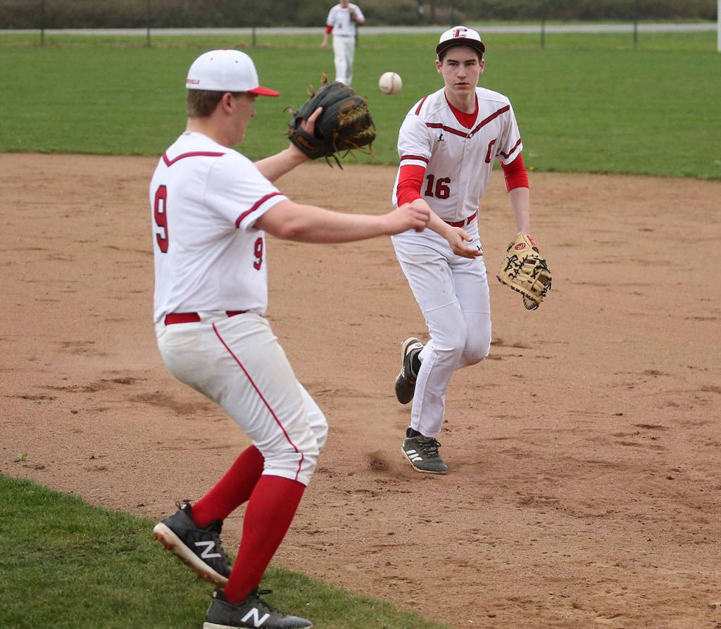 Coupeville first baseman Ulrik Wells, right, tosses to pitcher Dane Lucero covering the bag.(Photo by John Fisken)