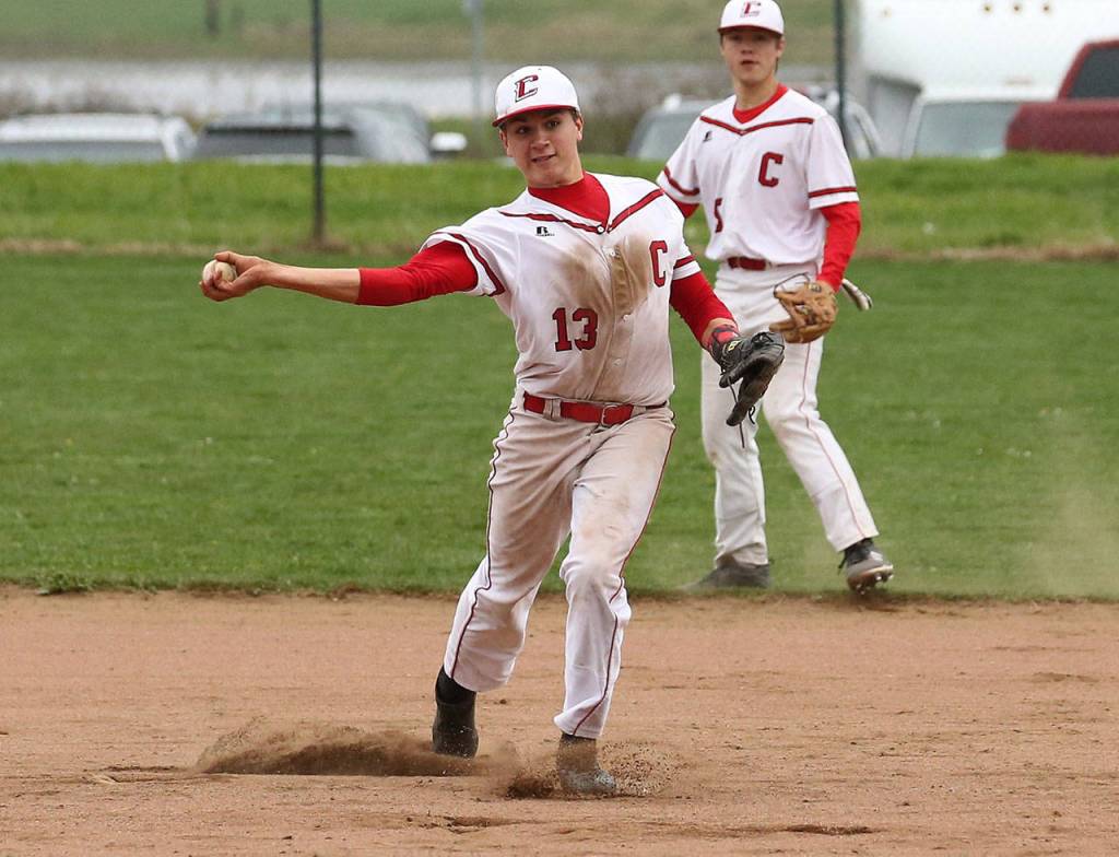 Third baseman Jake Pease throws to first as shortstop Matt Hilborn backs up the play.(Photo by John Fisken)