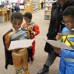 Photo by Laura Guido/Whidbey News-Times.                                Power Rangers Zjahnari Herrera, right, Azjahni Herrera, left, and Zjeziah Herrera, back, work on a scavenger hunt held throughout the Oak Harbor Library Saturday at WhidbeyCon. The free event is in its third year as a family-friendly way for locals to enjoy a comic convention.