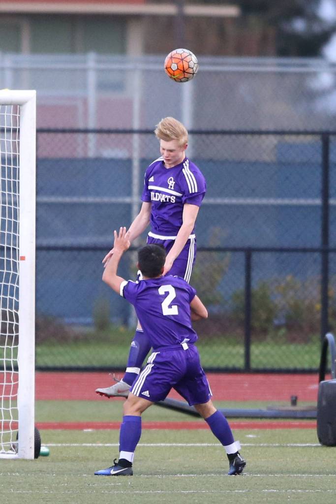 William Dylander heads the ball for the Wildcats as Kanoa King looks on. (Photo by John Fisken)