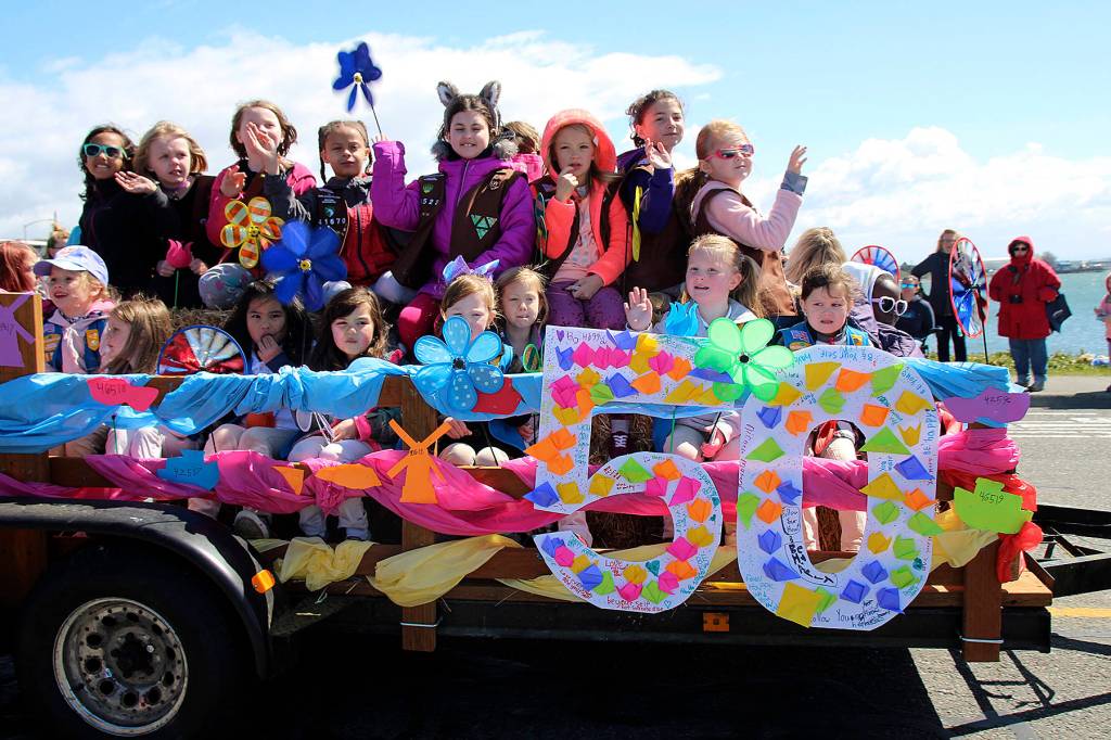 The Girl Scouts of Western Washington wave to the crowd at the Holland Happening parade, now in its 50th year.