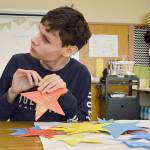 Levi Gonzalez helps string fishing line through the star decorations for Saturdays A Night to Remember prom. The free event is held for all people with disabilities age 14 and older. (Photo by Laura Guido/Whidbey News-Times)