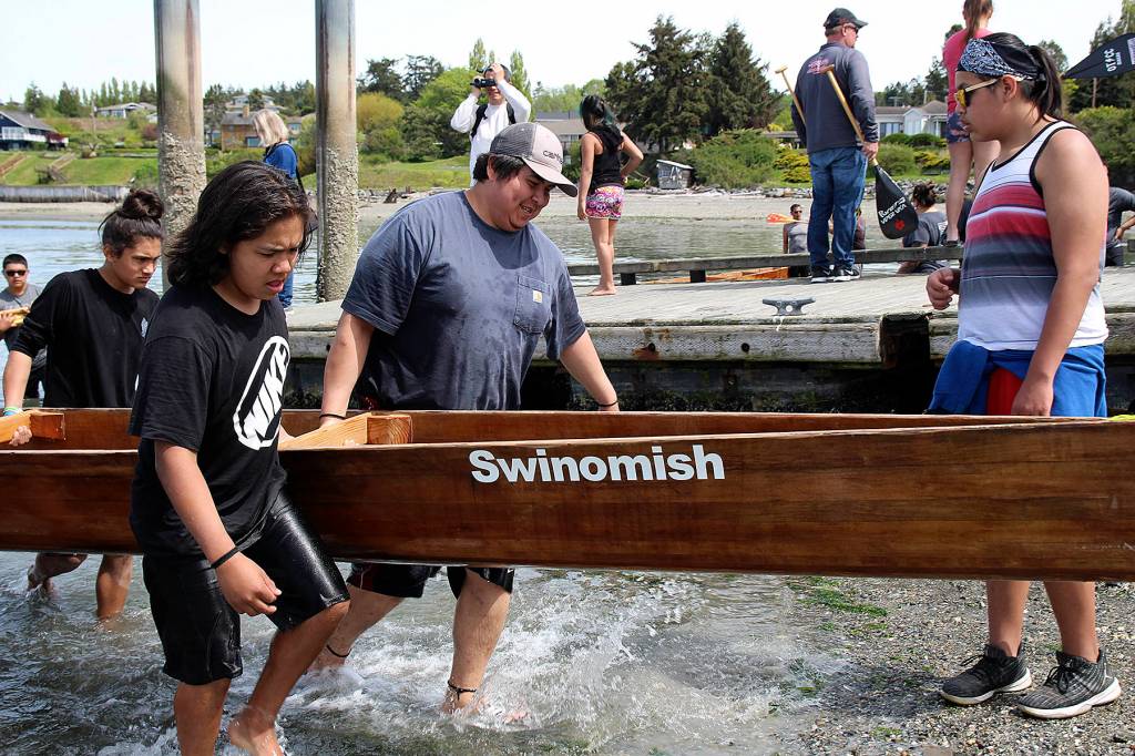 (Photo by Maria Matson/Whidbey News-Times)                                For the canoe pullers the hard work doesnt stop when the race is over. Each team, including this team with the Swinomish tribe, hauls their sturdy canoes out of the water and to their vehicles to make way for the next competing teams. Paddlers train for months in preparation for the competition.