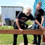 House captain is Gary Wray checks that a beam of lumber fits properly on the deck in progress as volunteer Devin Short watches. Wray is also the president of the North Whidbey Hearts & Hammers. (Photo by Maria Matson/Whidbey News-Times)