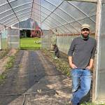 Photo by Harry Anderson/Whidbey News-Times -                                 Tyler Hanson stands outside the hoop house at Kettles Edge Farm where he is growing tomatoes.