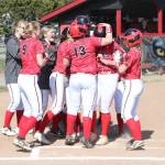 Sarah Wright is mobbed by her teammates after hitting a first-inning home run.(Photo by John Fisken)