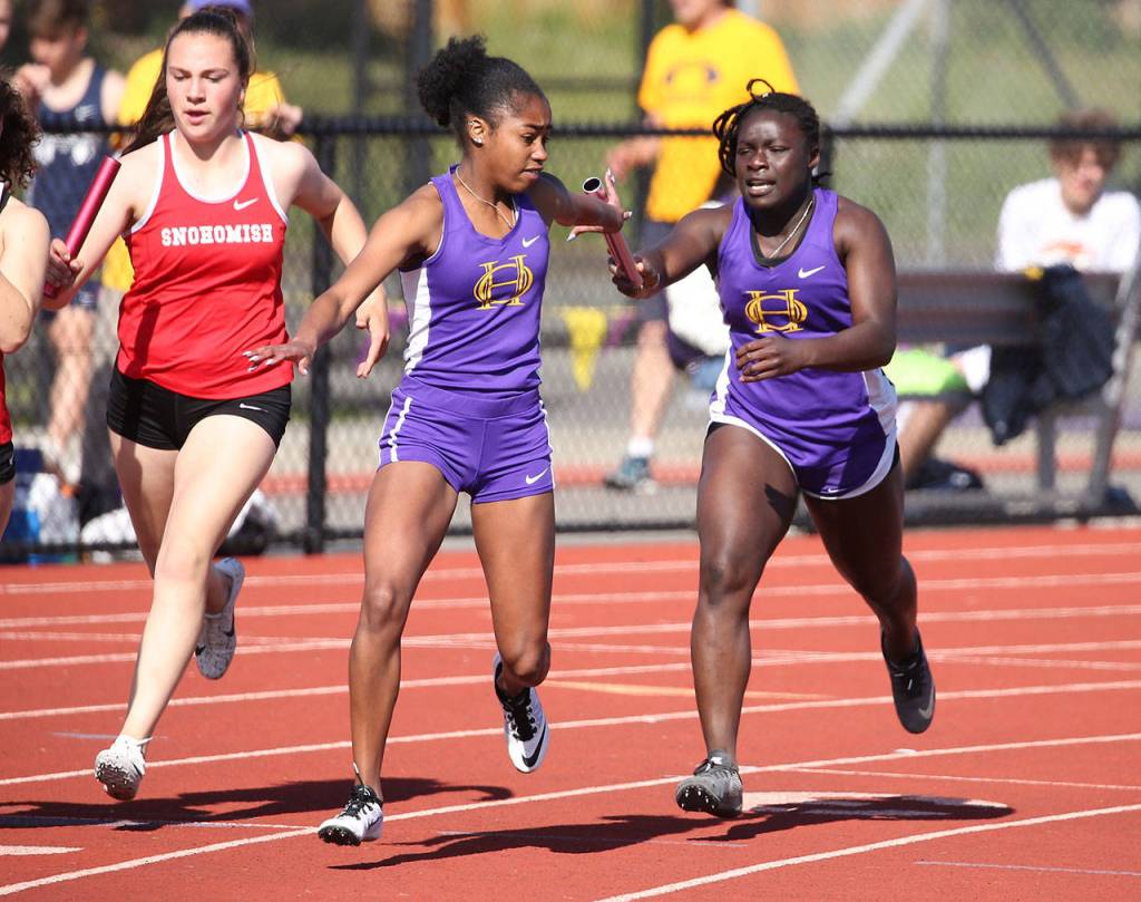 Oak Harbors Jessica Vester, center, receives the baton from Maria Dailey in the 4x200 relay. They teamed with Leielle Salinger and Morgan Pease to place third in the event.(Photo by John Fisken)