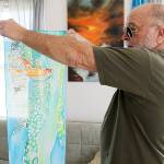 Kent Sanders holds up a scarf painted by his late wife Dottie Sanders, a prolific artist. Photo by Laura Guido/Whidbey News-Times