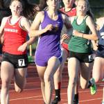 Natalie French (purple uniform) runs through the final turn in the 800; she finished second.(Photo by John Fisken)