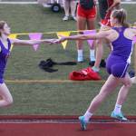 Oak Harbors Brenna Rothman hands the baton to Morgan Pease in the 4x400 relay Friday. Rothman, Pease, Natalie French and Courtney VanGiesen joined forces to win the event for the Wildcats. (Photo by John Fisken)
