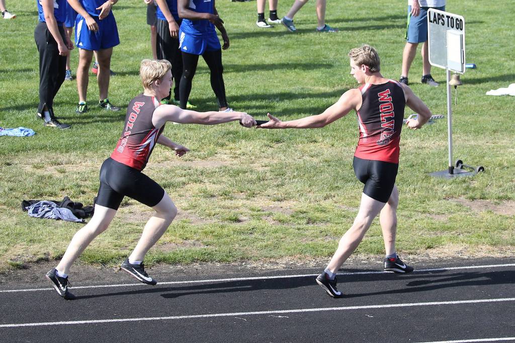 Jaschon Baumann hands the baton to Tiger Johnson in the 4x400 relay.(Photo by John Fisken)