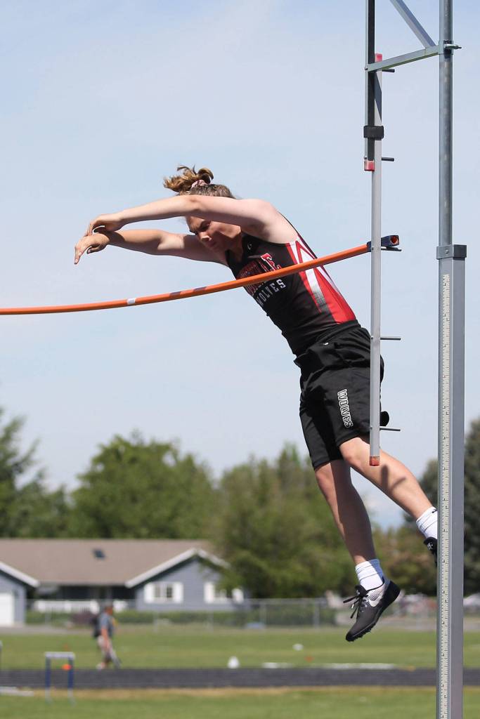 Thane Peterson clears the bar in the pole vault.(Photo by John Fisken)