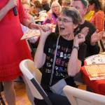 Shannon OPhelan celebrates after winning a round at Not Your Grandmas Bingo Saturday night at Bayview Hall. One of the hosts Bobbi Jo Blessings, who also goes by Kerry Nielsen, verifies her card. Proceeds from the event go toward Island Senior Resources.