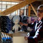 Peggy Gilmer looks over a ten-panel piece called Unhinged Reflections by Coupeville High School student Casey Rogers at the Art with a Message exhibit. On view until June 9 at Bayview Cash Store, the annual all-island high school art show is sponsored by Goosefoot. Photo by Patricia Guthrie/Whidbey News Group