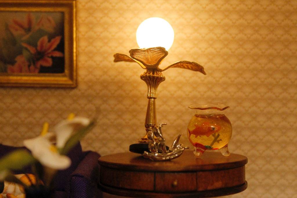 A living room table, complete with a lamp and a goldfish bowl.