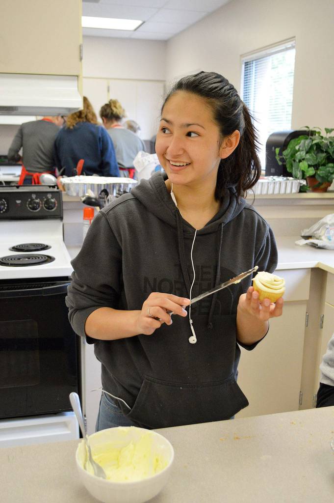 Eighth grader Angelique Robin frosts her teams entry into a cupcake competition at North Whidbey Middle School. Photo by Laura Guido/Whidbey News-Times