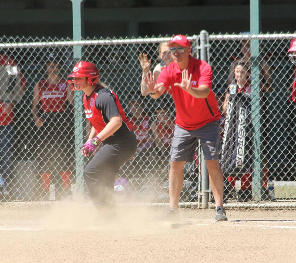 Coach Fred Farris puts up the stop sign as McMillan rounds third with a standup triple.(Photo by Jim Waller/Whidbey News-Times)