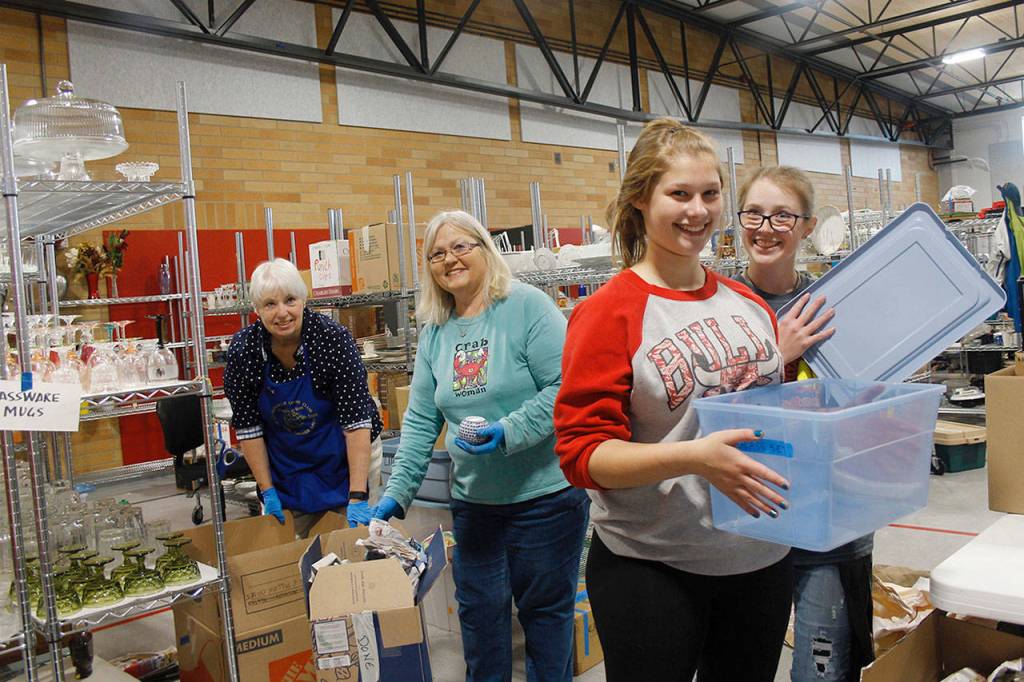 From left to right: Volunteers Linda Youngs, Susan Haworth, Ivy Leedy and MacKenzie Davis sort through donated items. Youngs and Haworth are Lions members and Leedy and Davis are members of the Coupeville Softball team.                                (Photo by Maria Matson/Whidbey News-Times)